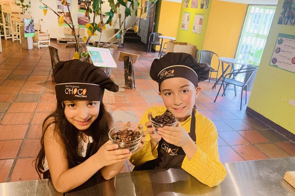 Two kids make chocolate at the Coco Museum in Cartagena.