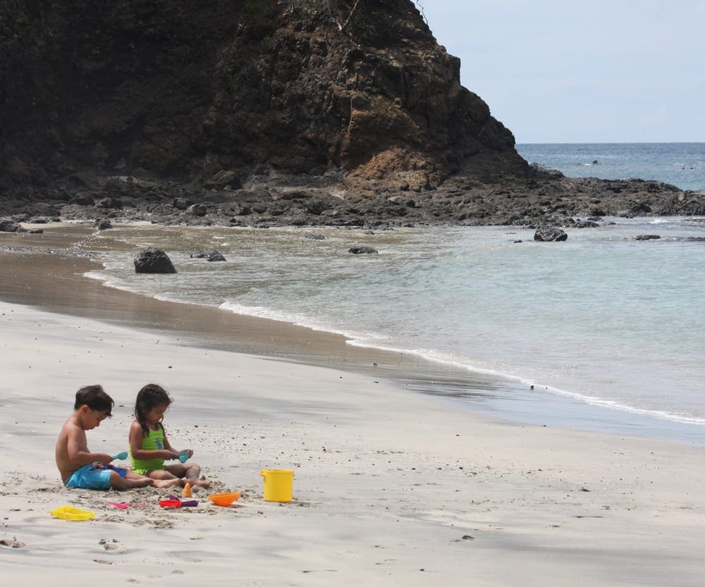 Little boy and girl playing on the beach with beach toys in Costa Rica.