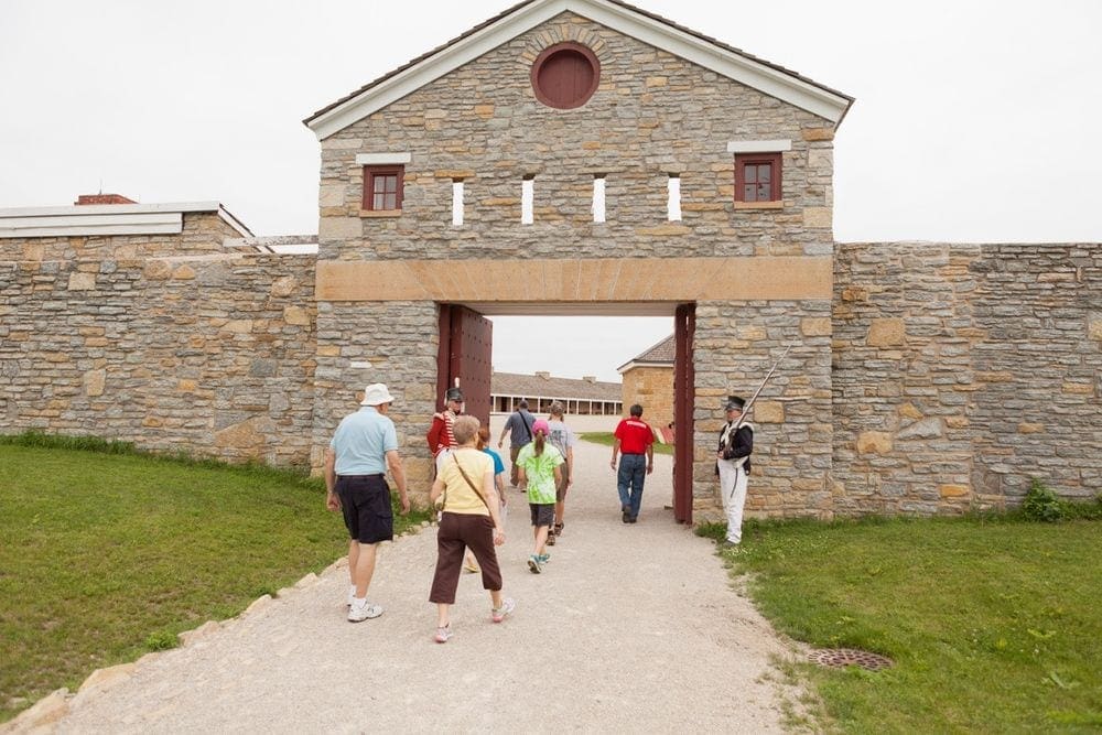Several guests walk through the gates into the Historic Fort Snelling, one of the best things to do in Minneapolis with kids.