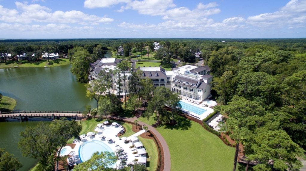 An aerial view of the pristine grounds and resort buildings of Montage Palmetto Bluff, one of the best family hotels in Hilton Head, on a sunny day.