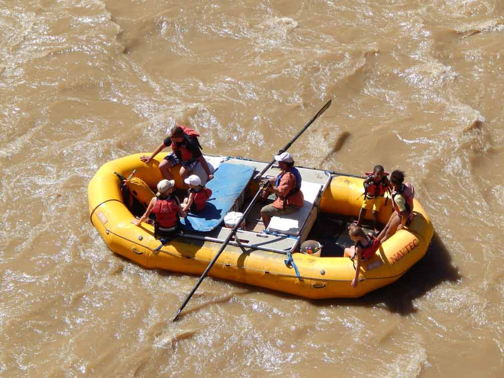 An aerial view of a yellow raft carrying several passangers on a tour with Navtec Expeditions.