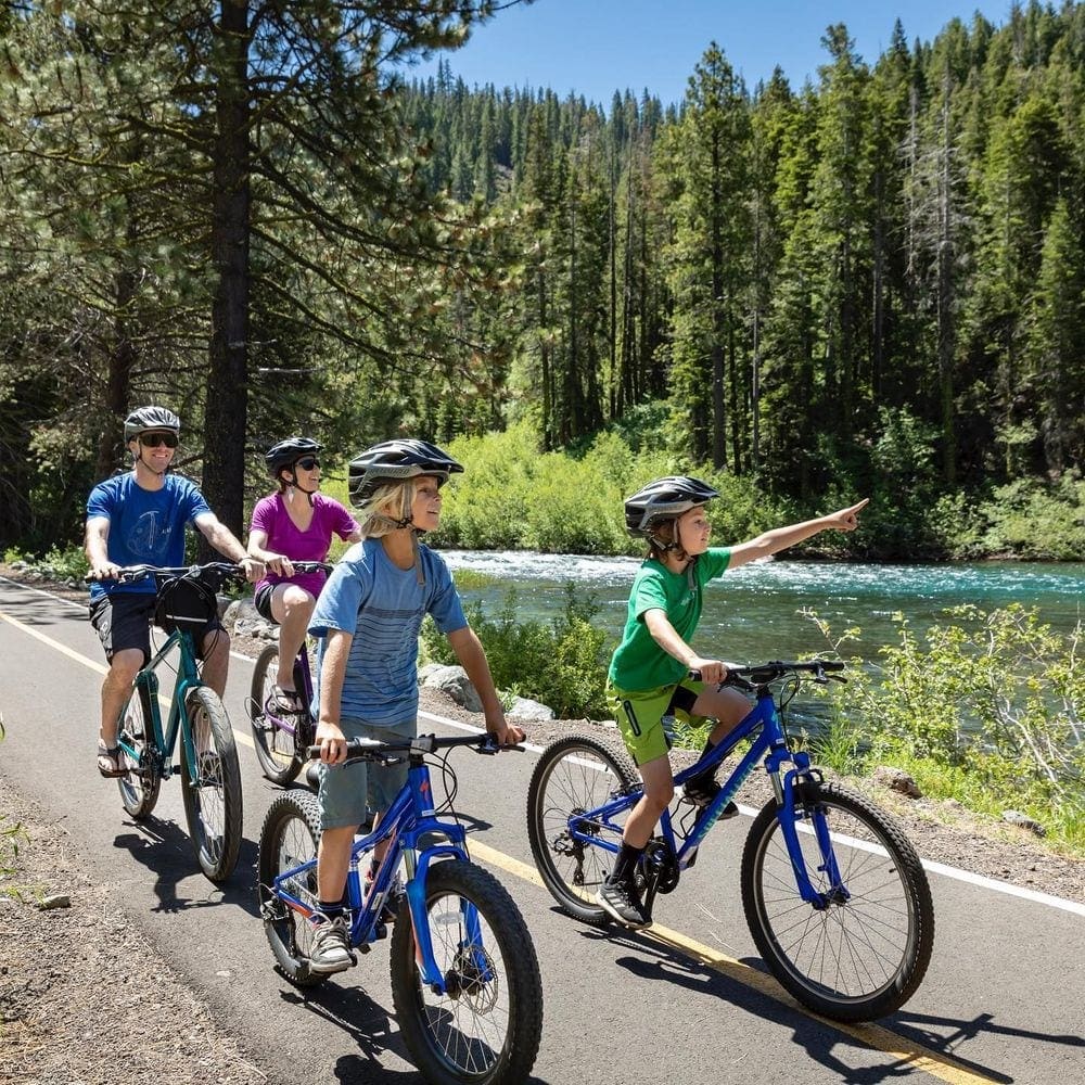 A family of four enjoys a scenic bike ride along a rive rnear Lake Tahoe.