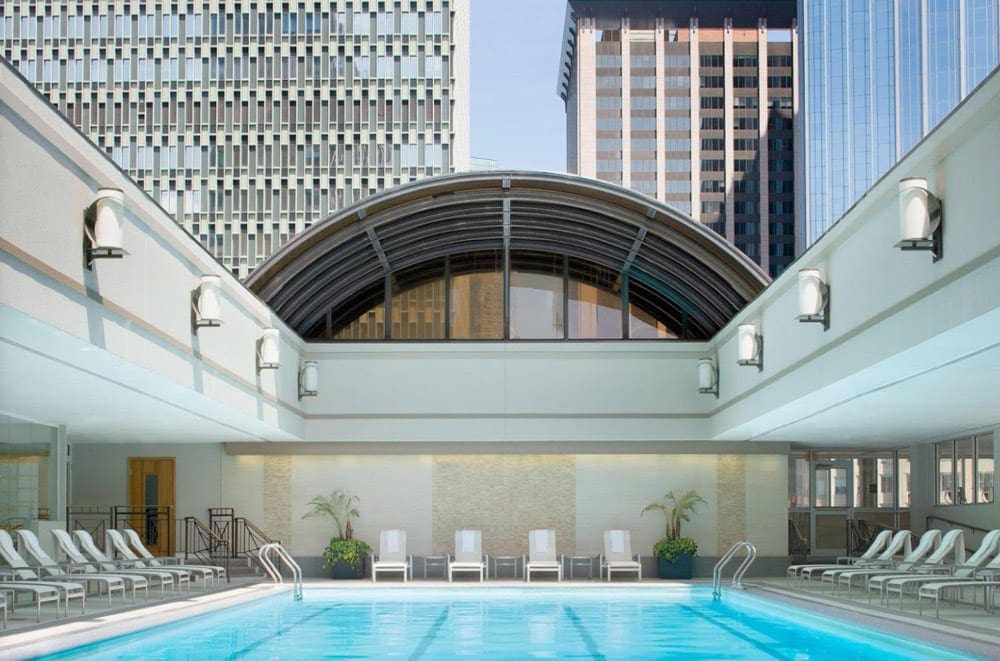 The brighly lit indoor pool at the Sheraton Boston Hotel, flanked by loungers on all sides.