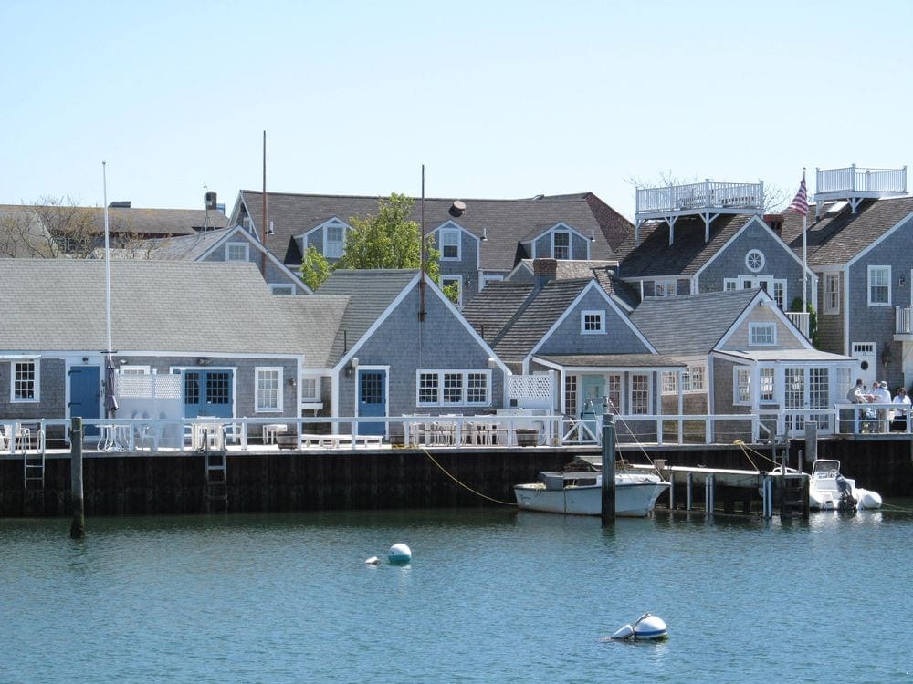 A view of Nantucket from the water, featuring shoreline docks and iconic Nantucket homes.