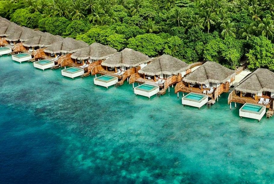 Several over-water bungalows rest along the edge of the Dusit Thani Maldives.