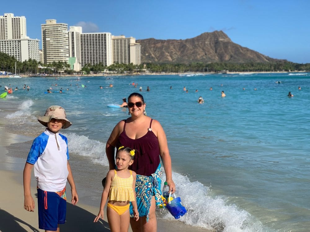 A mom and her two kids stand on Hanauma Bay in Hawaii.