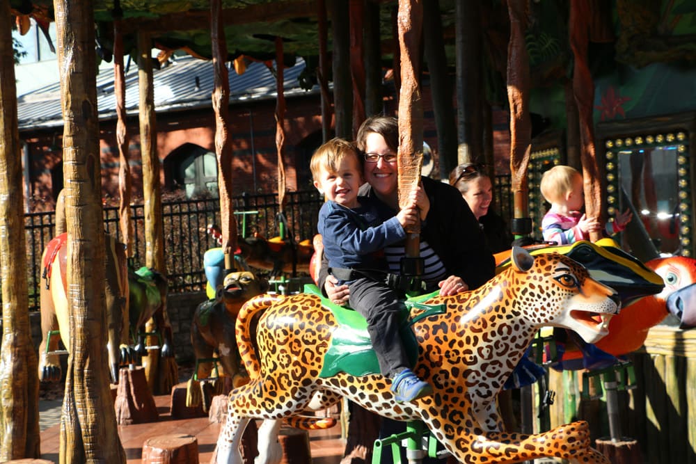 A mom and her young son enjoy a ride on a carousel at the Philadelphia Zoo.