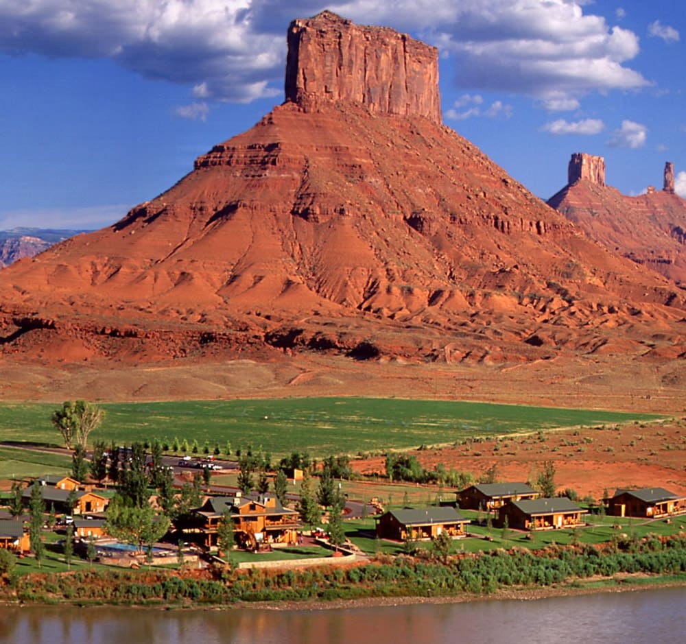 An aerial view of Sorrel River Ranch Resort and Spa, with Utah's iconic red rock formations in the distance.