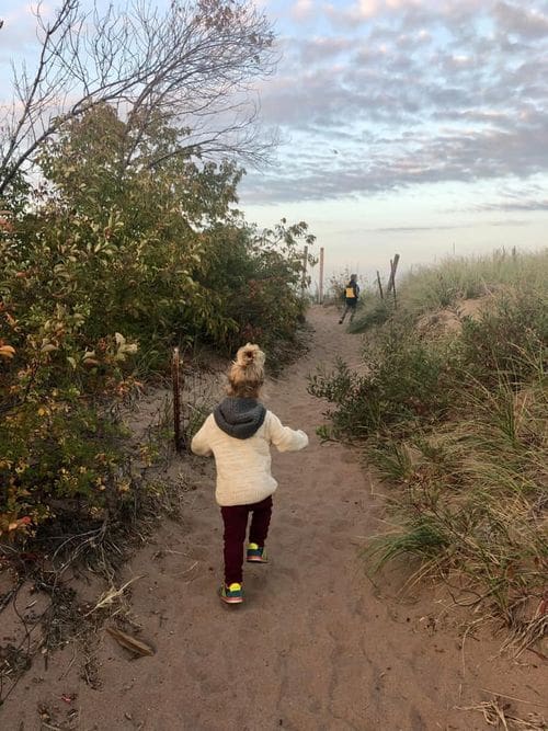 A young girl wanders down a sandy path in Park Point in Duluth, Minnesota.