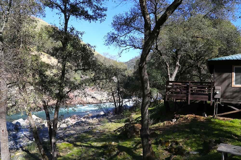 A view of a Cabin deck overlooking the river at the American River Resort in Coloma, an ideal stay on your Bay Area weekend getaways with kids.