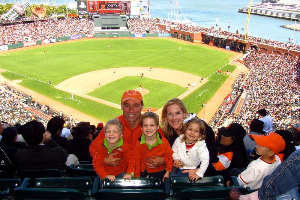 A family of five poses together in the stands at a Giant's game, one of the best things to do in San Francisco with kids.