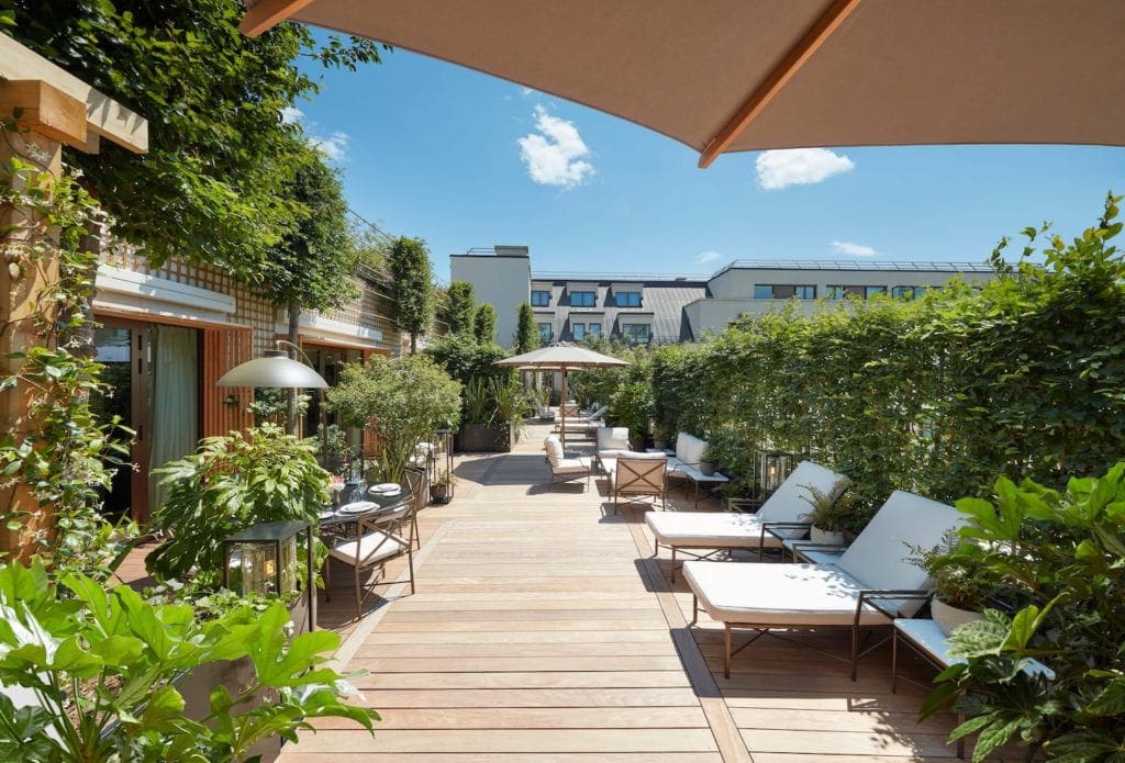 An outdoor relaxation area, featuring lush plants and loungers, at the Mandarin Oriental, Paris, one of the best Paris hotels for families.