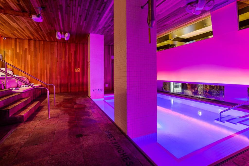 The pink and purple-hued pool at the Room Mate Grace Hotel, one of the best family hotels in New York with pools.