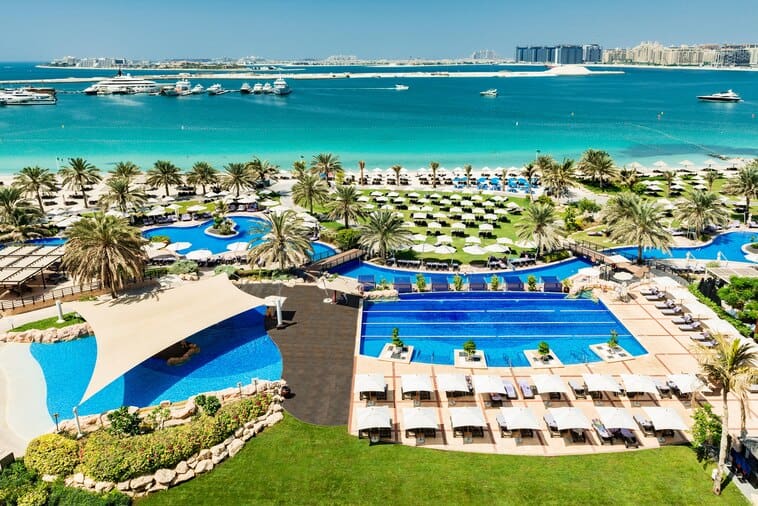 An aerial view of the large pool and pool deck with loungers at the The Westin Dubai Mina Seyahi Beach Resort & Marina.