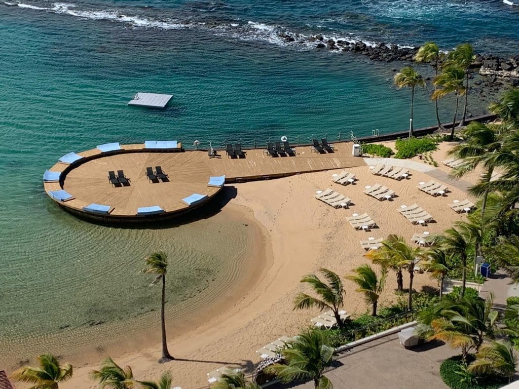 Aerial view of the private beach at the Caribe Hilton, perfect for kids of all ages and one of the best family resorts in Puerto Rico.