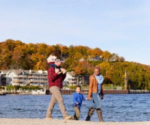 A family of four walks together on a crisp fall day along the water near Sister Bay in Door County, Wisconsin.
