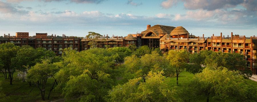 The exterior of the Disney’s Animal Kingdom Lodge, featuring a lush canopy of trees and an African-themed building.