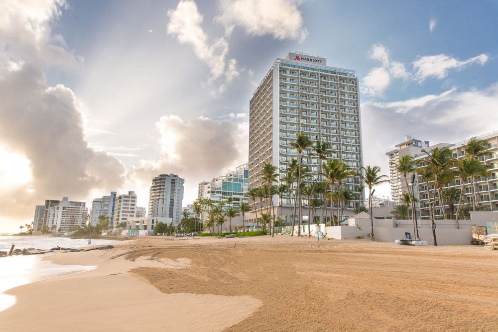 The exterior of the San Juan Marriott Resort & Stellaris Casino, along the beach on a sunny day.