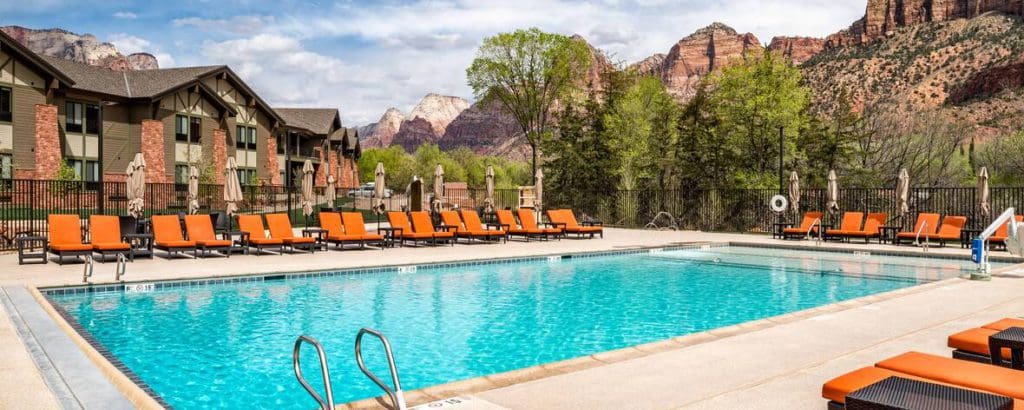 The outdoor pool and pool deck at Springhill Suites by Marriott Zion National Park, with desert rock formations in the distance.