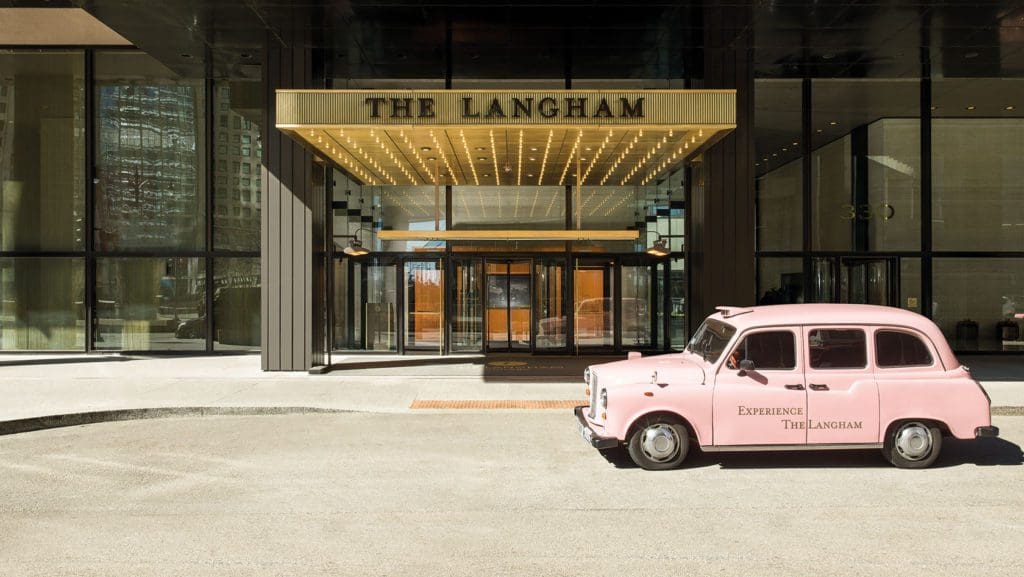The entrance of the Langham Chicago with a pink company car parked in front. It's one of the best family hotels in Chicago.