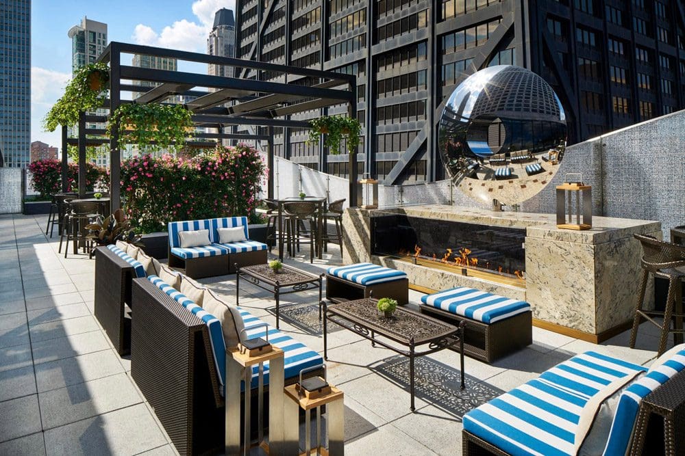 A rooftop sitting area, featuring striped white and blue cushions and a great view, atop the The Ritz-Carlton, Chicago.