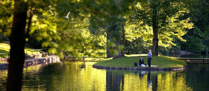 Two people enjoy a lovely day in a shady spot on Dufferin Island, one of the best things to do in Niagara Falls with kids.