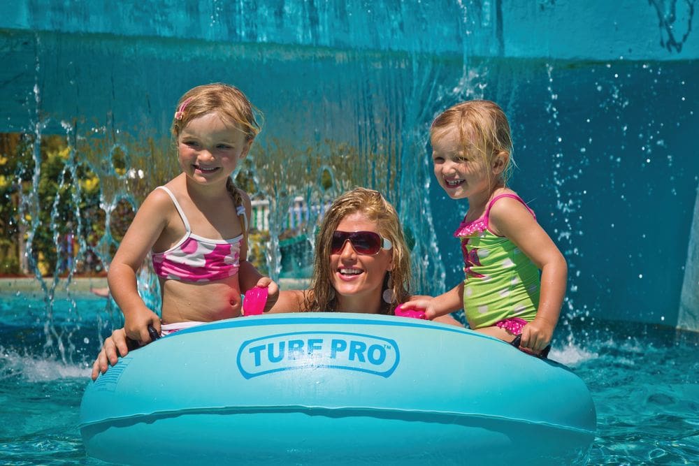 A mom and two of her kids sit in a Tube Pro while enjoying the pool at the Coconut Bay Beach Resort & Spa, one of the best hotels in the Caribbean with a water park for families.