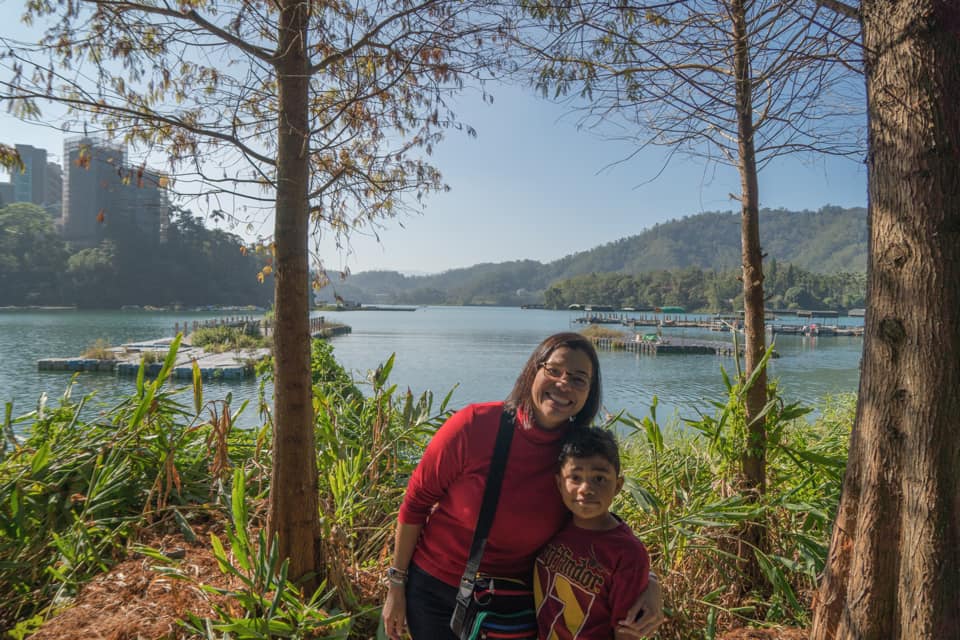 A mom and her son pose together in front of Sun Moon Lake in Taiwan.