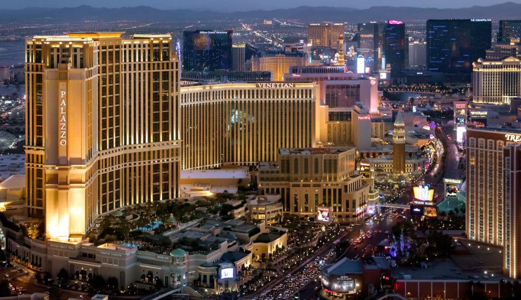 An aerial view of the The Venetian Resort® and surrounding buildings at night, one of the best hotels in Las Vegas for families.