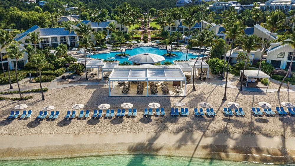 An aerial view of the shoreline with beach loungers, pool, and resort grounds of the The Westin St. John Resort Villas.
