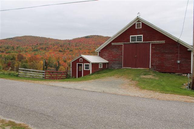 A red barn nestled amongst brilliant fall foliage in Sugar Hill, New Hampshire.