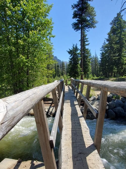 A wooden bridge leads over a fast moving river at Icicle Gorge Trail.