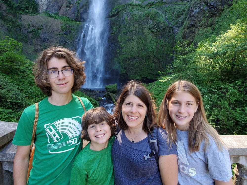A mom and her three kids pose in front of Multnomah Falls, near Portland.
