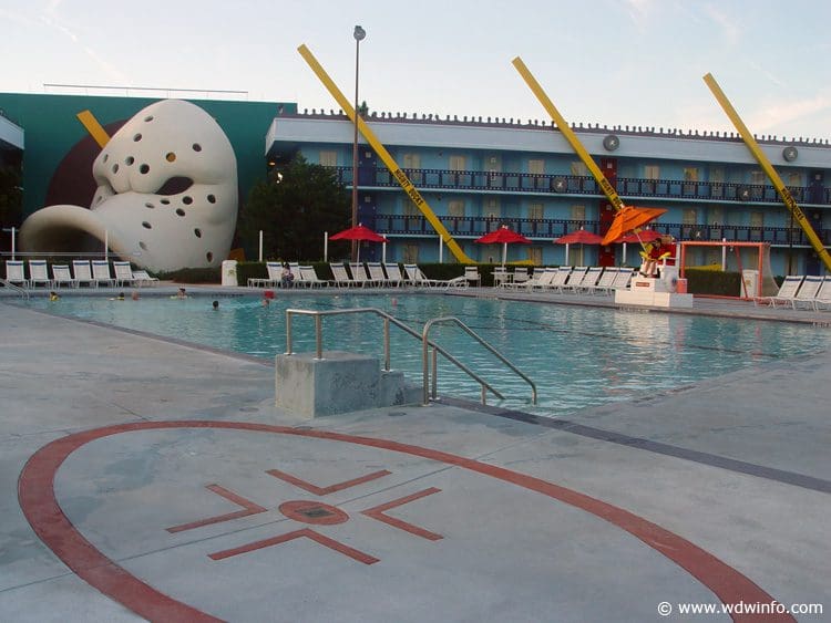 The pool at the Disney’s All-Star Movies Resort, surrounded by resort buildings with a statue from the Mighty Ducks on one side.