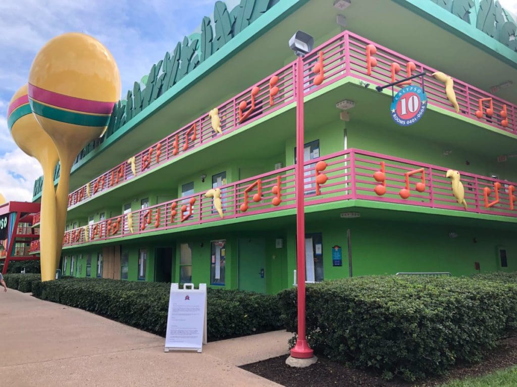 The side of one of the hotel buildings at Disney’s All-Star Music Resort, decorated in bright green, with maracas on one side.