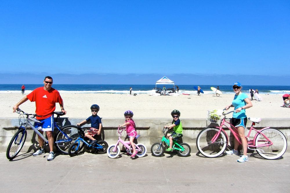 A family of five enjoys a bike ride around Belmont Park in San Diego.