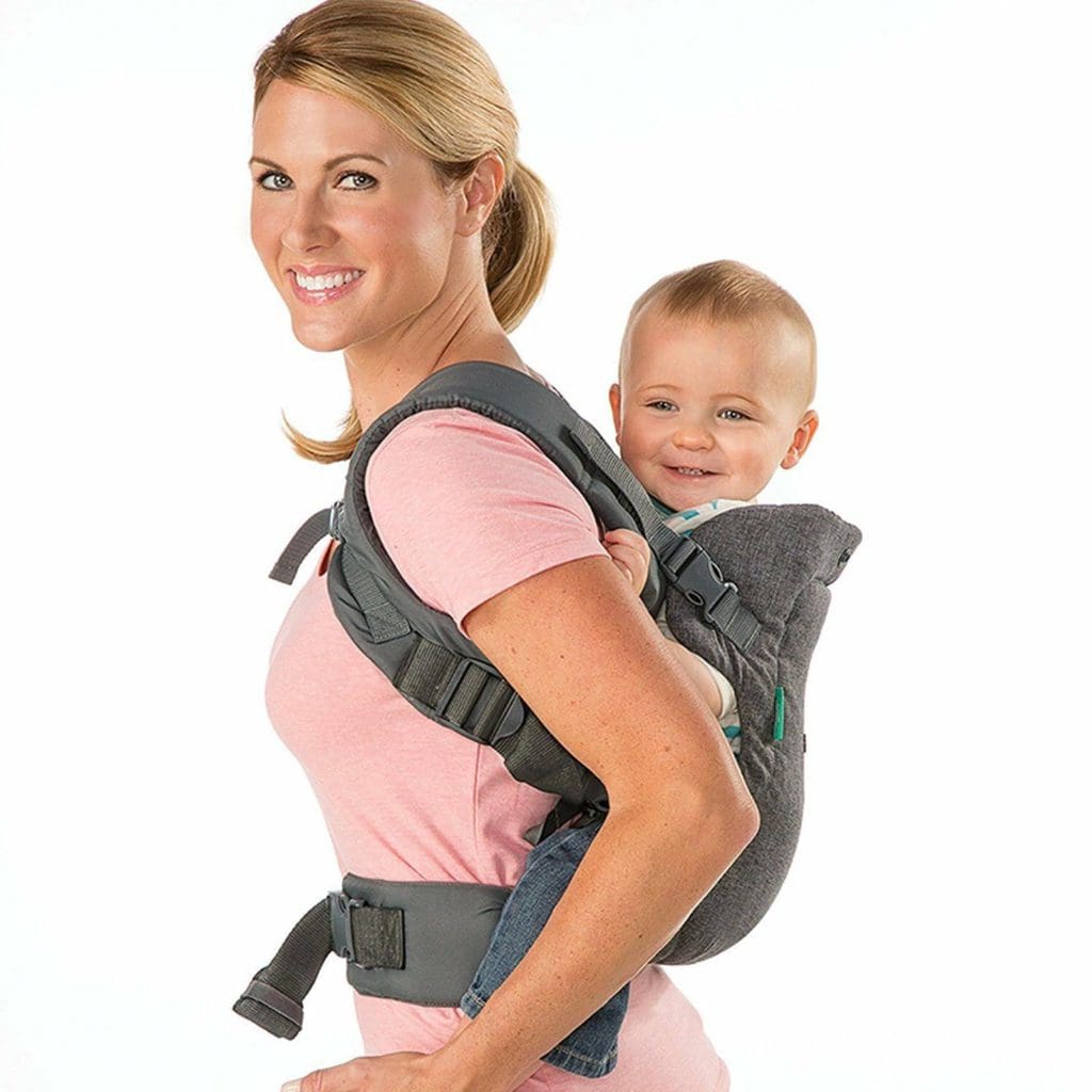 A mom holds her child on her back using a Infantino Flip Advanced 4-in-1 Carrier, one of the best baby carriers for travel.