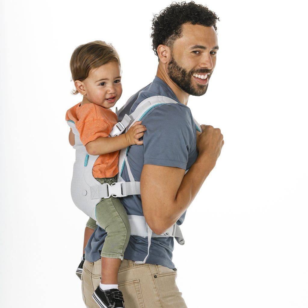 A man of color holds his child on his back using a carrier from Infantino Flip Advanced 4-in-1 Carrier.