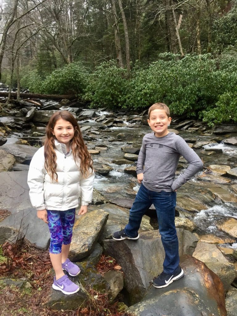 Two girls stand together in a rock stream while hiking in Northern Georgia.
