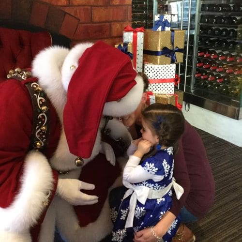 A young girl talks with Santa at the Macy's Christmas breakfast.