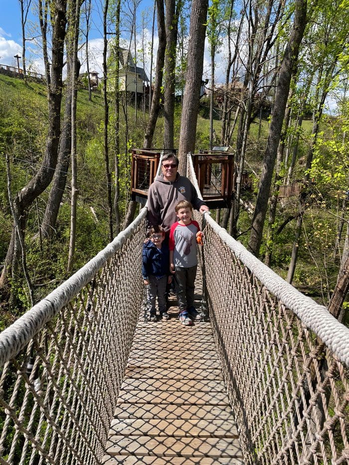 A dad and his two sons cross a roped bridge at Anakeesta Theme Park.