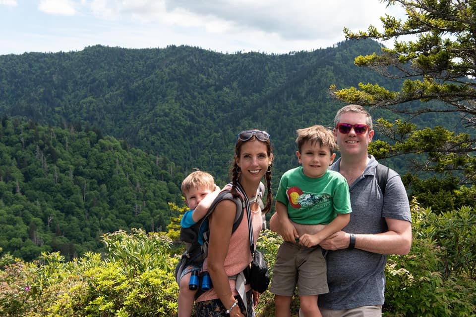 A family of four poses together, while hiking along the Alum Cave Trail, one of the best things in a family itinerary for Gatlinburg Pigeon-Forge.