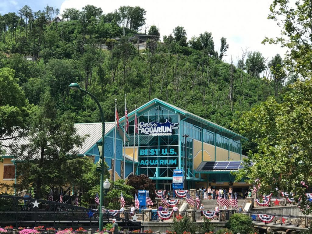 A view of the entrance to the Ripley’s Aquarium of the Smokies, surrounded by lush greenery.