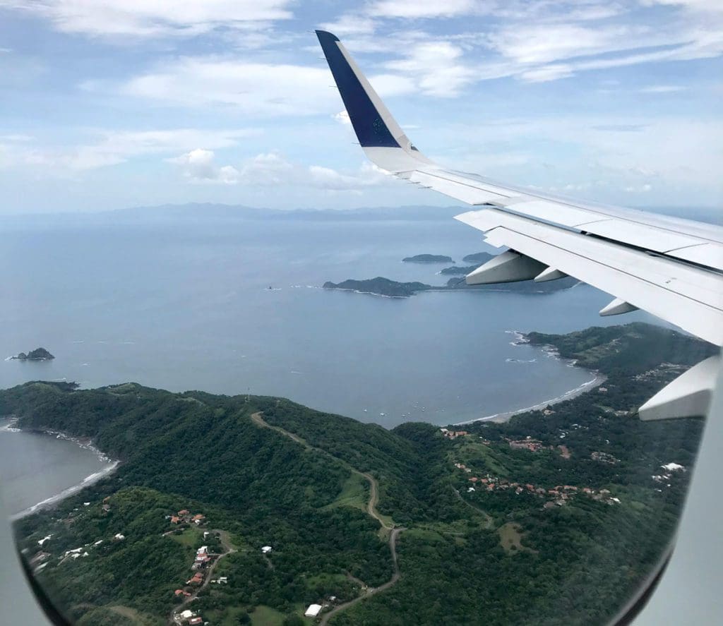 A view of Costa Rica and the Papagayo Gulf from an airplane, the wing of the plane can be seen.