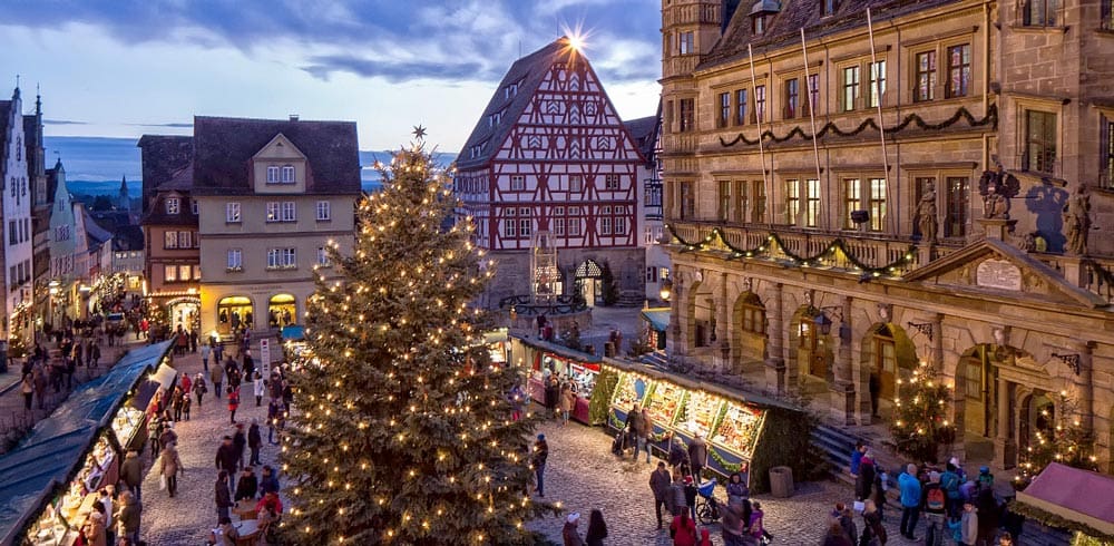 An aerial view of the large square holding the Rothenburg ob der Tauber Christmas Market, featuring a huge tree and market area.
