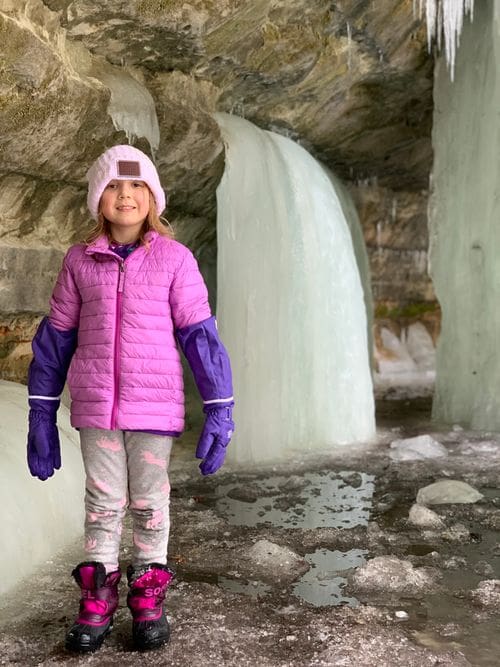 A young girls stands near one of the ice flows at Eben Caves.