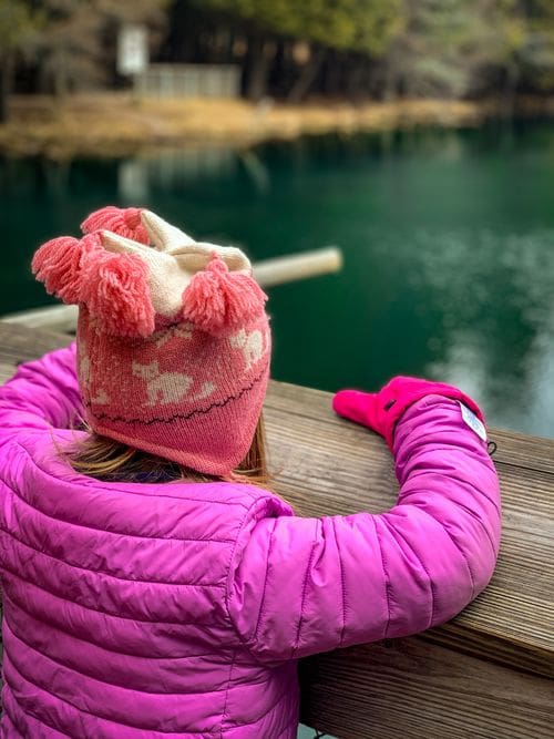 A young girl looks at the beautiful clear waters of Kitch-iti-kipi from the raft.