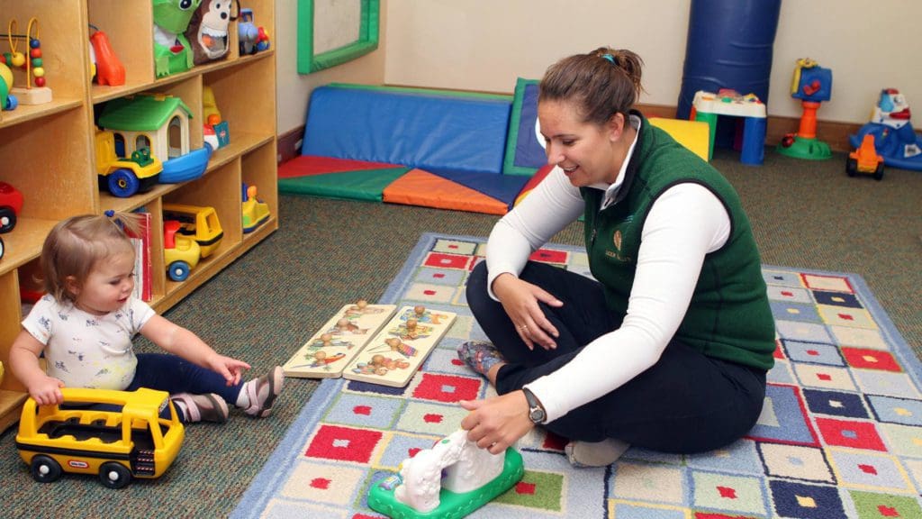 A chid-care worker sits with a small child at the Deer Valley Children’s Center.