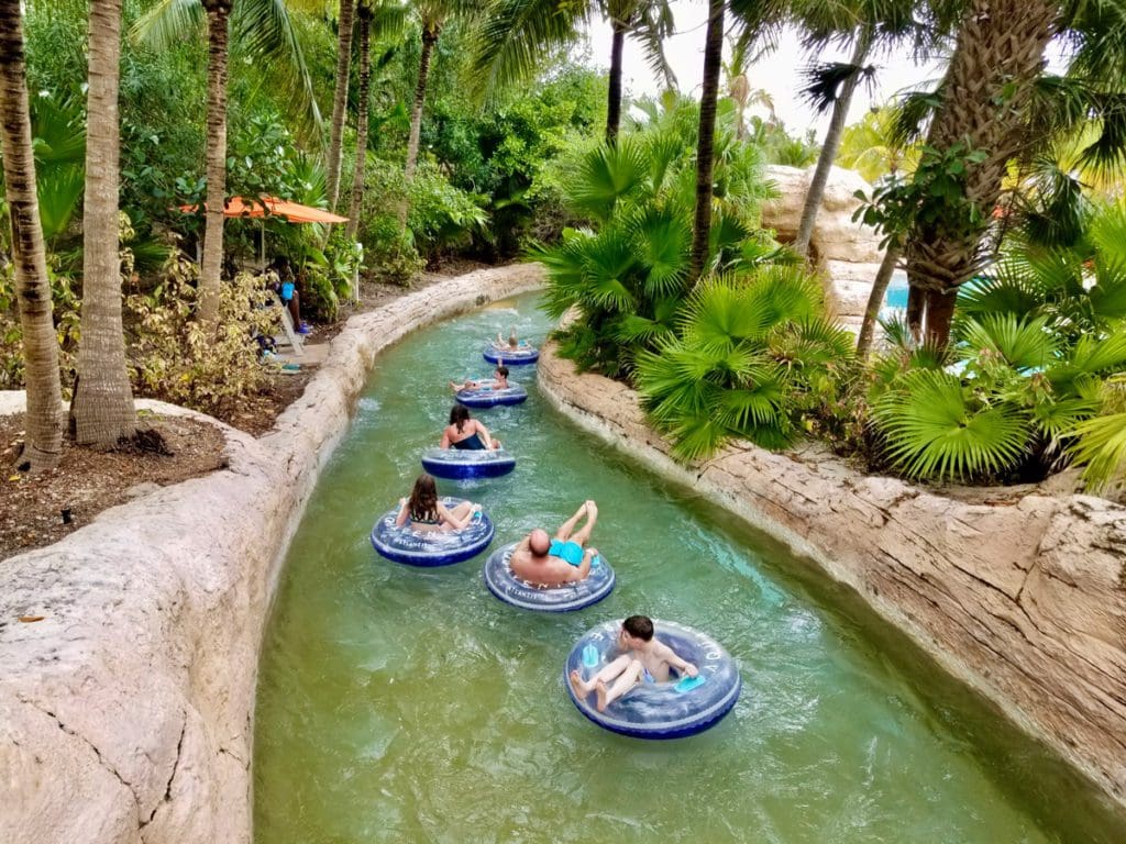 A line of people enjoy tubing down a lazy river.