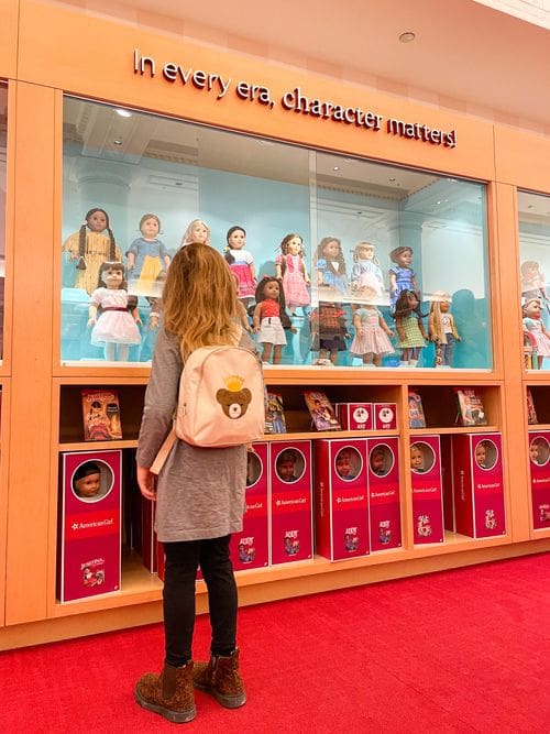A young girl looks at a large case of American Girl dolls, while shopping at American Girl Place in Chicago.